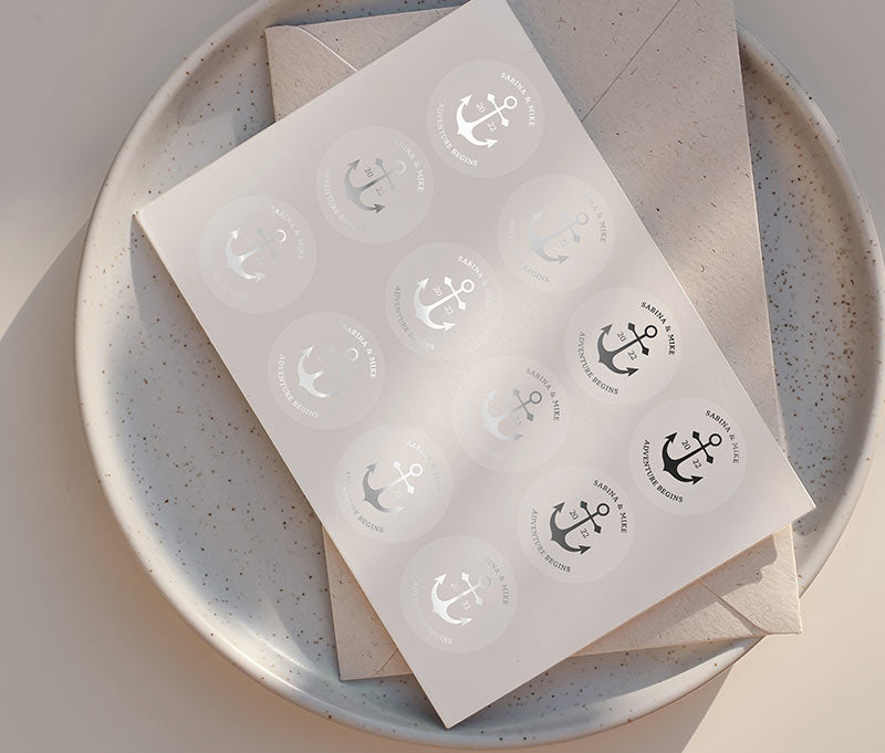Navy theme Anchor graphic and personalised names silver foil printed on round clear wedding sticker sheet