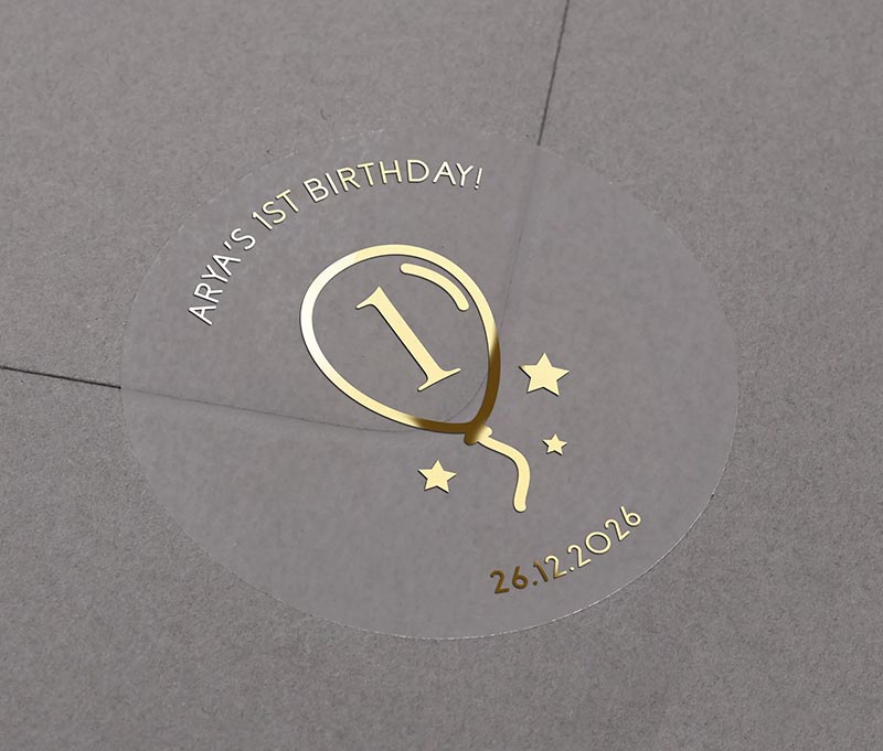 Gold foil printed birthday stickers with balloon graphic and personalized name and date applied to an envelope