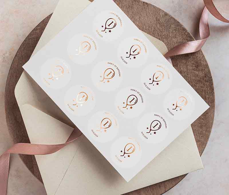 Birthday sticker sheet with a balloon graphic and personalized name and date printed in rose gold on a clear sticker