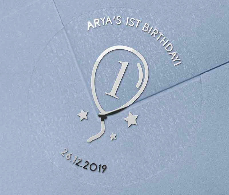 Birthday stickers with a balloon graphic and personalized name and date printed in silver on a clear sticker