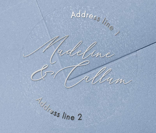 Return address labels printed in silver on clear round sticker with names in calligraphy font