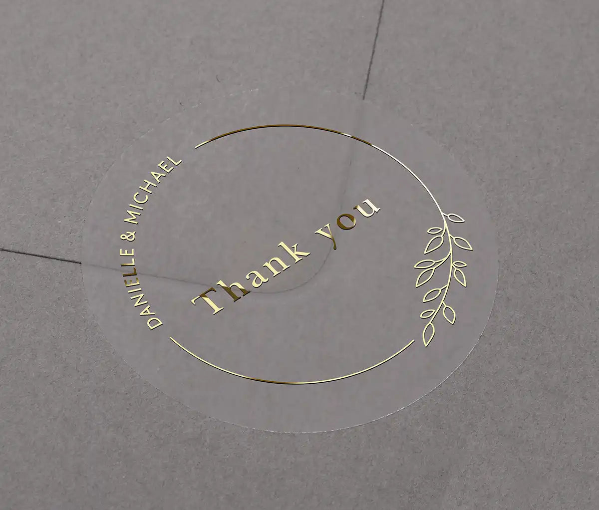 Wedding thank you sticker with personalized names and delicate floral theme frame printed in gold on clear sticker