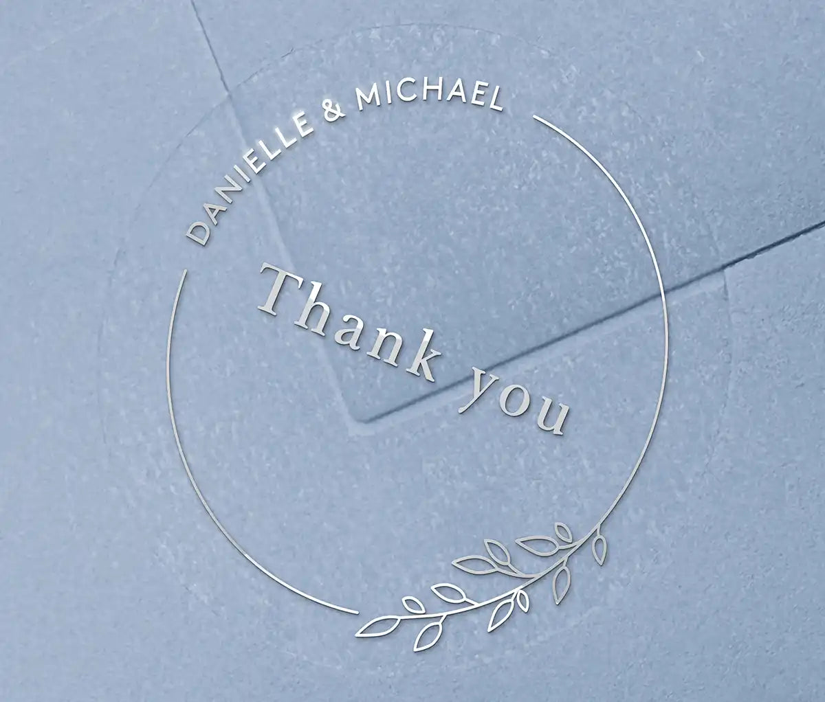 Wedding thank you sticker with personalized names and delicate floral theme frame printed in silver on clear sticker