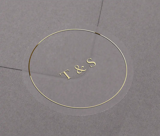 Wedding envelope sticker with personalized initials printed in gold on a clear sticker