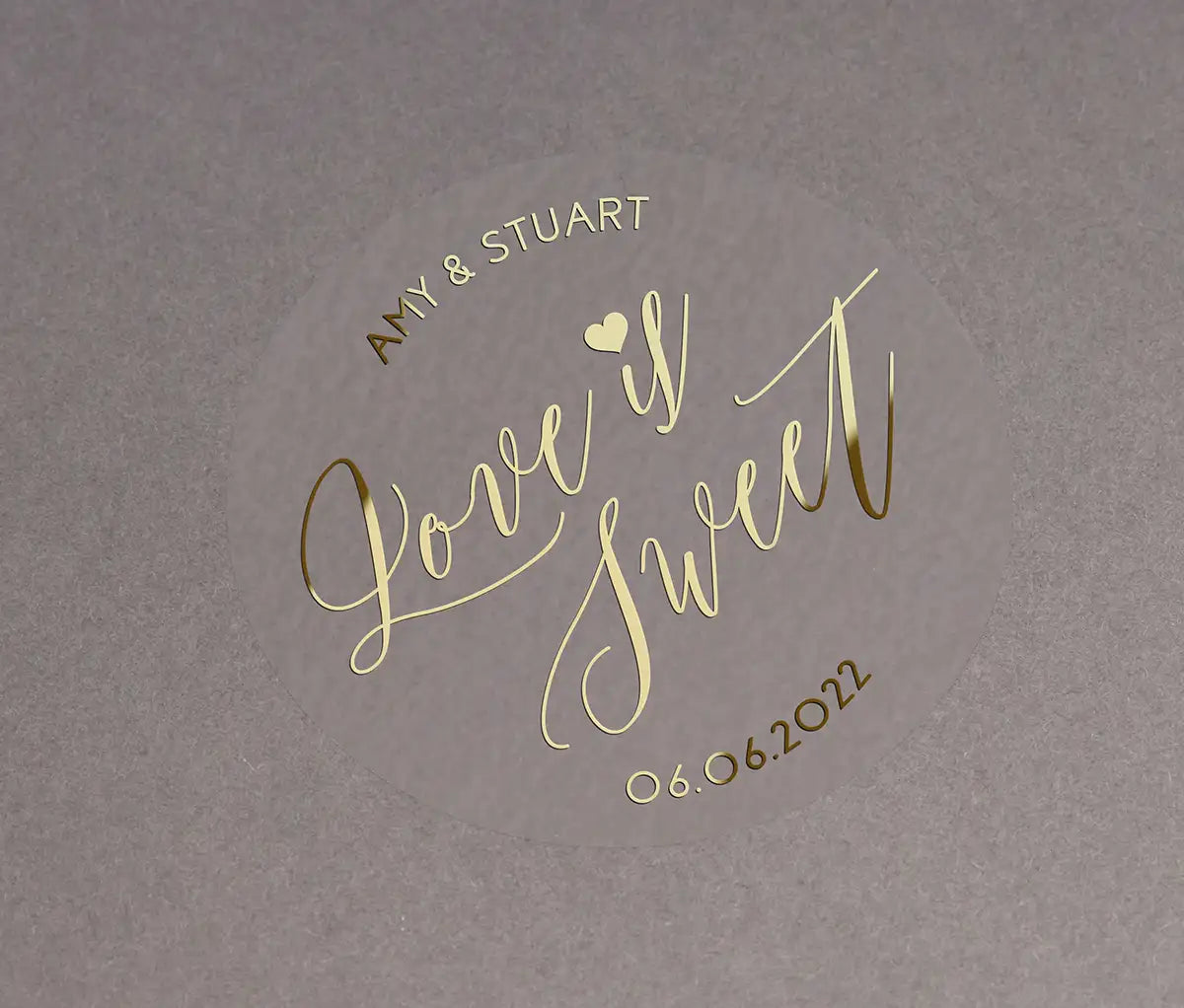 Love is sweet wedding favor sticker with heart graphic personalized names and date printed in gold on clear sticker