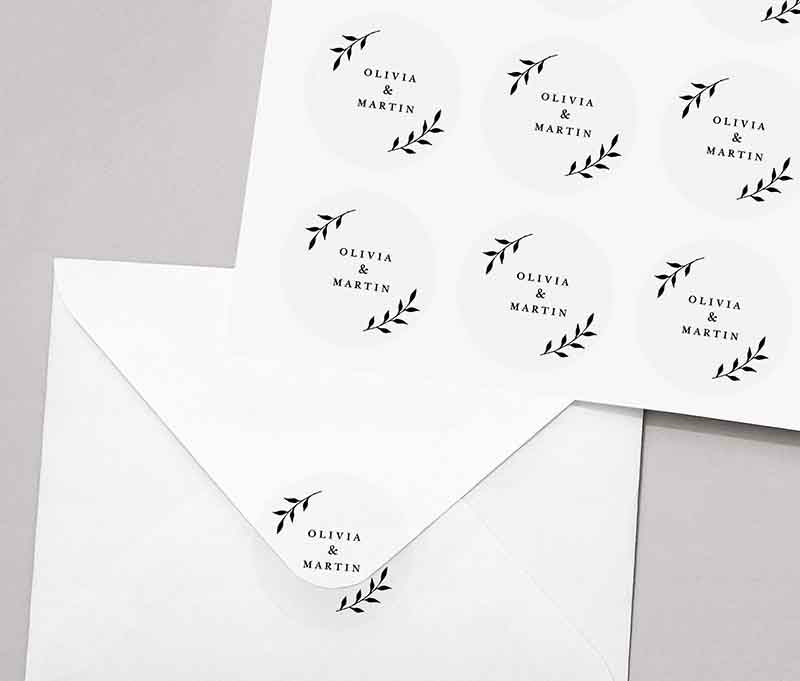 Round sticker sheet with personalized names and laurel leaves graphic printed in black on round transparent frosted labels