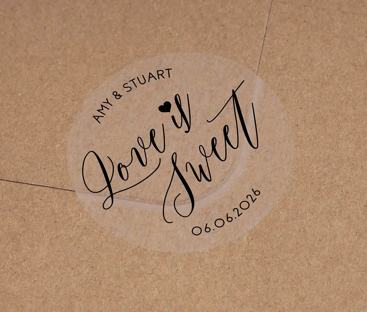 Love is sweet wedding favor sticker with heart graphic personalized names and date printed in black on clear sticker