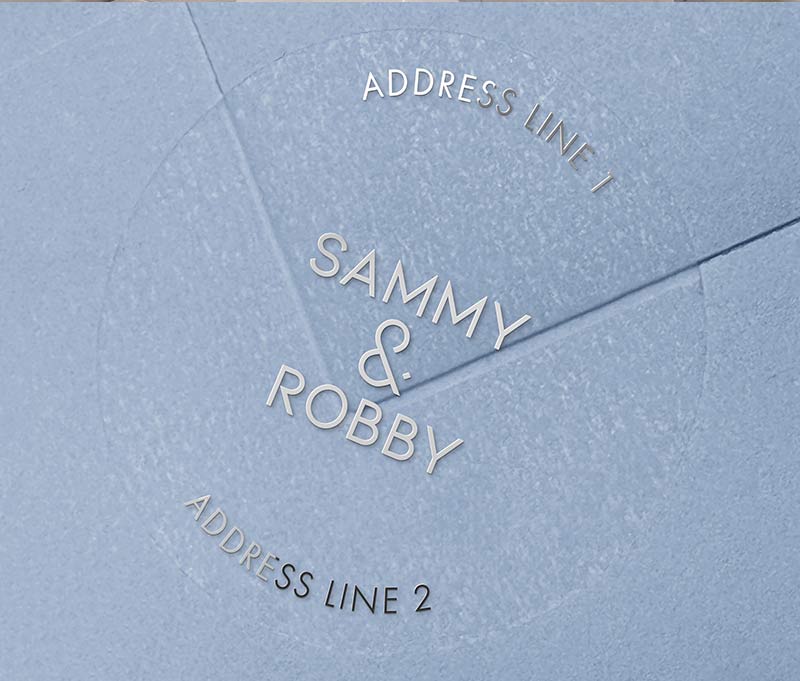 Return address labels with silver foil printing on clear round labels, applied to an envelope.