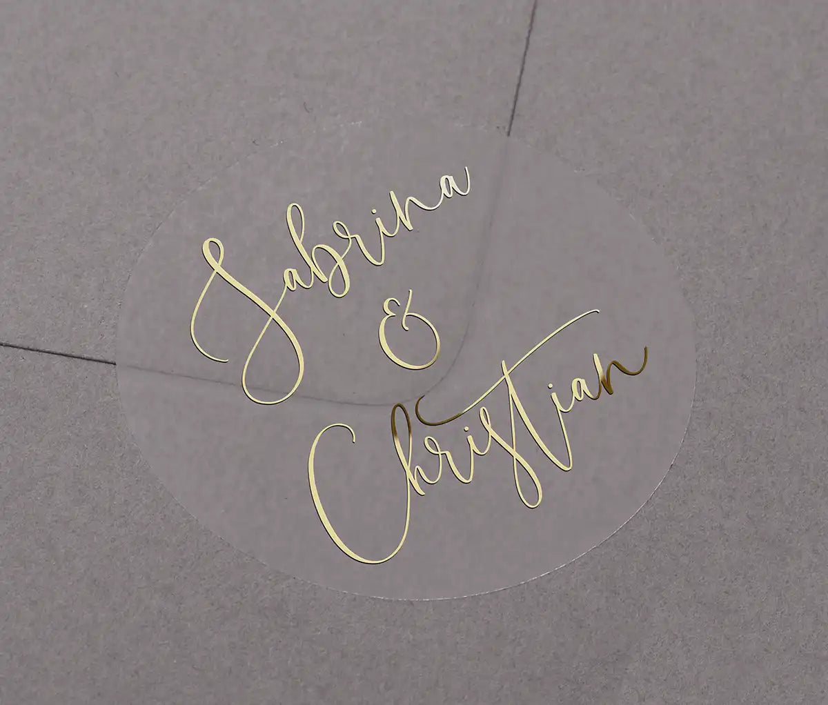 Wedding favor stickers with personalized names printed in gold foil on clear round sticker