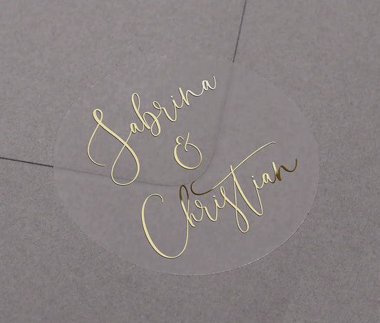 Wedding favor stickers with personalized names printed in gold foil on clear round sticker