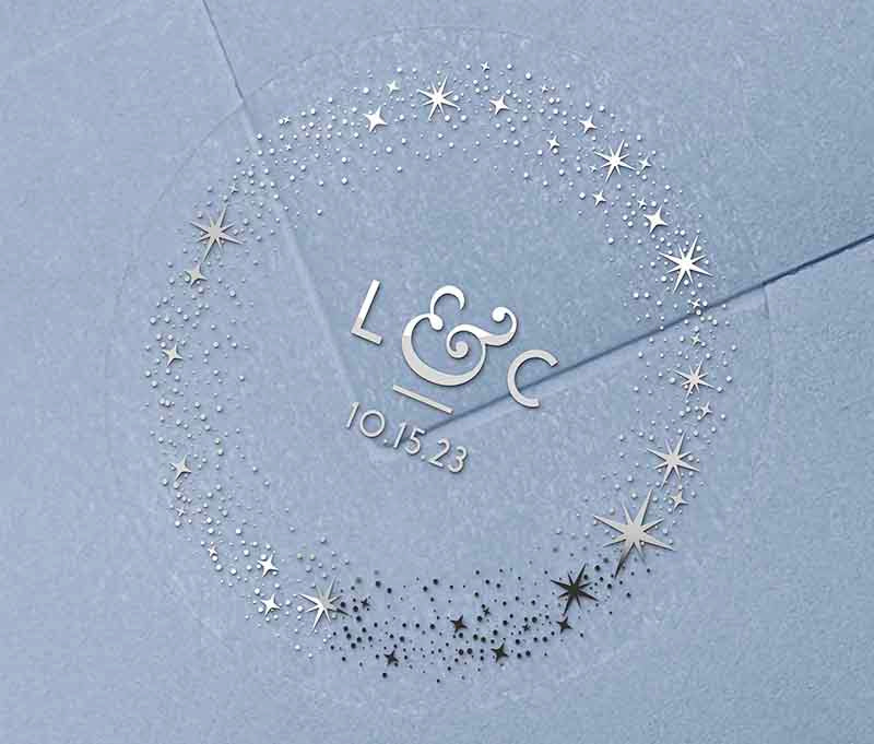 Celestial wedding favor stickers with stars around personalised initials and date printed in silver on clear sticker