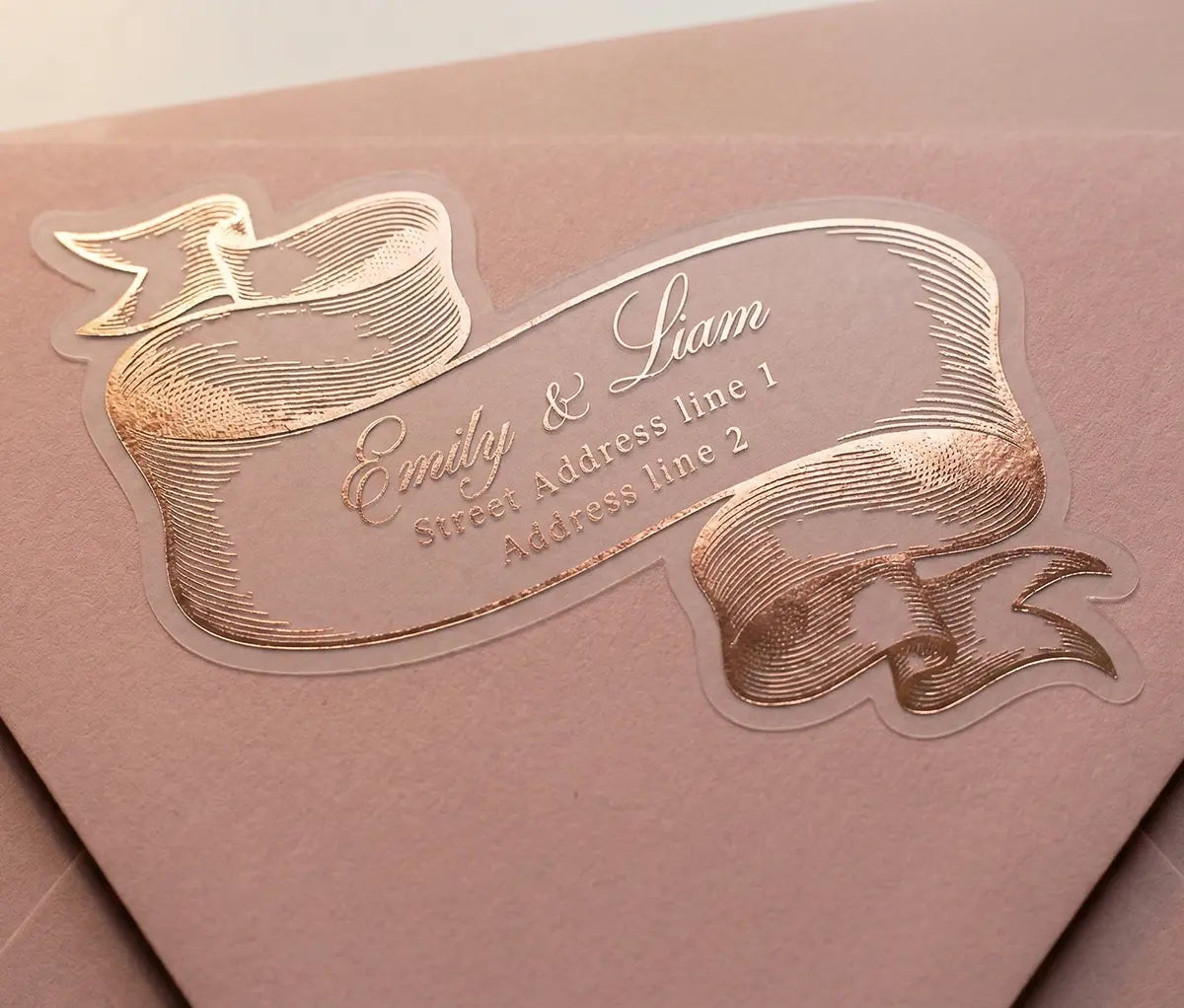 Rose gold vintage-style return address label on a pink envelope