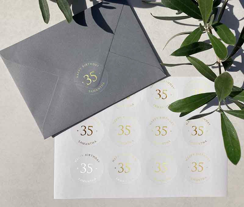 Personalized age and name birthday sticker sheet printed in rose gold foil on transparent frosted round stickers