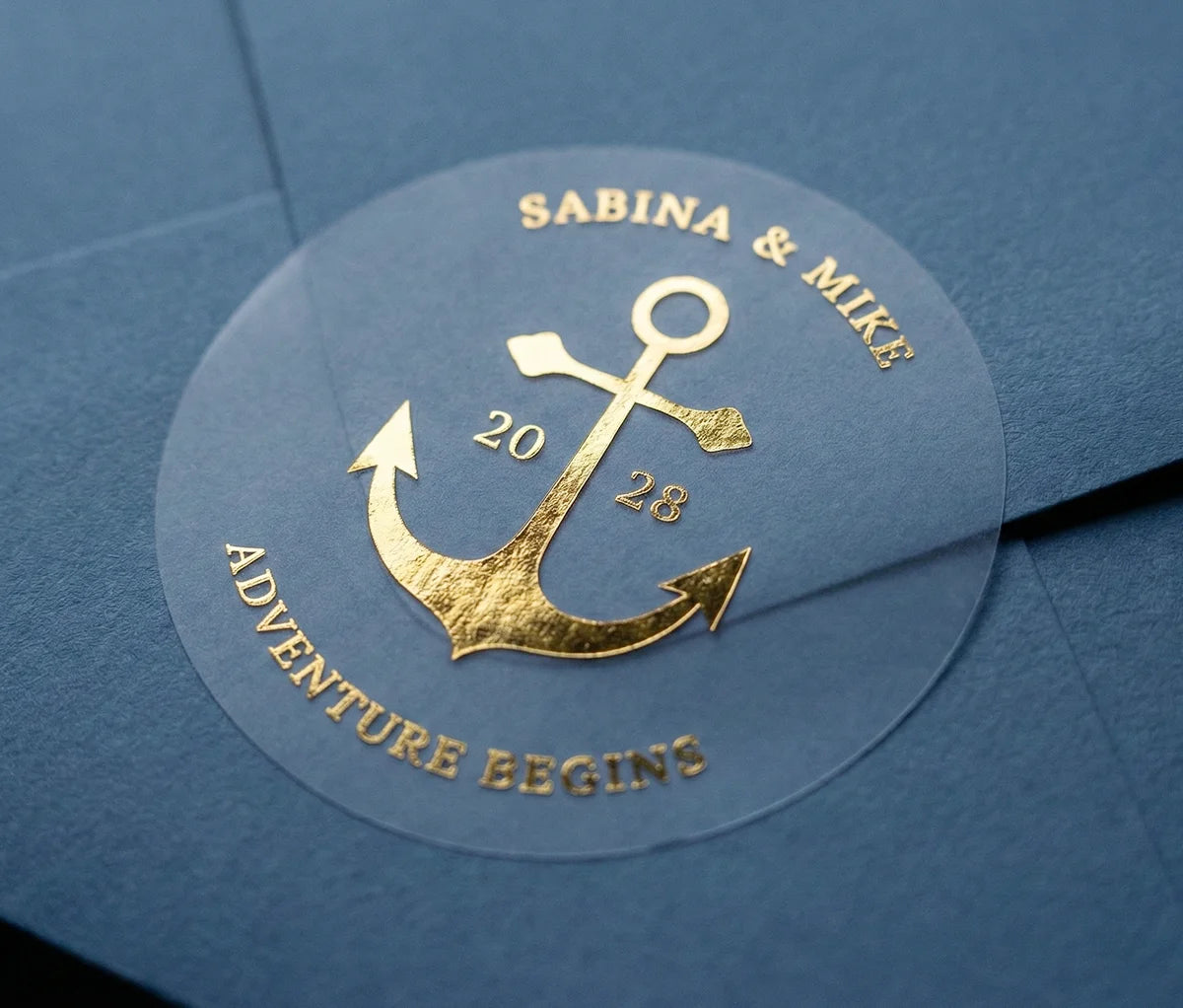 Personalized wedding sticker with anchor graphic printed in gold foil applied to a navy colour envelope.