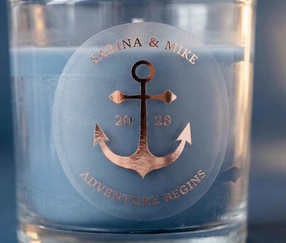 Personalized frosted wedding sticker with an anchor graphic printed in rose gold foil applied to a navy colour candle.