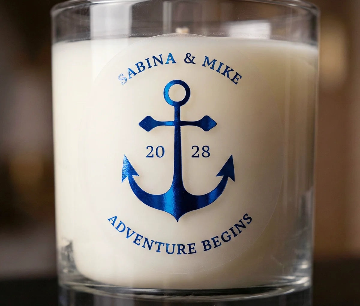 Personalized frosted wedding sticker with an anchor graphic printed in royal blue foil applied to a cream colour candle.