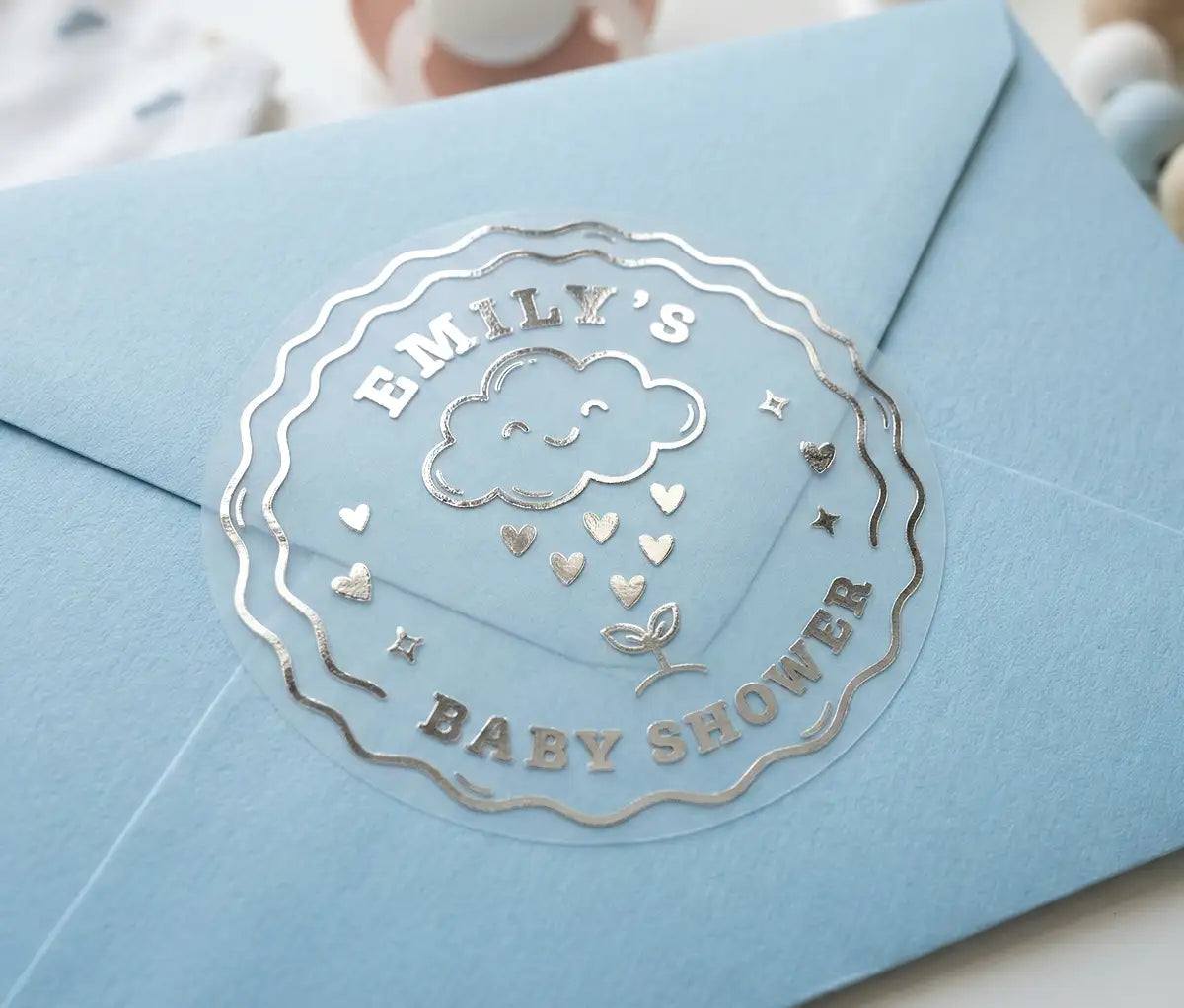 Cute cloud raining hearts Baby shower stickers with custom name printed in silver foil sealing an envelope