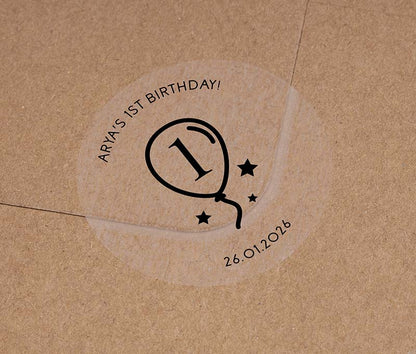Birthday stickers with a balloon graphic and personalized name and date printed in black ink on a clear sticker