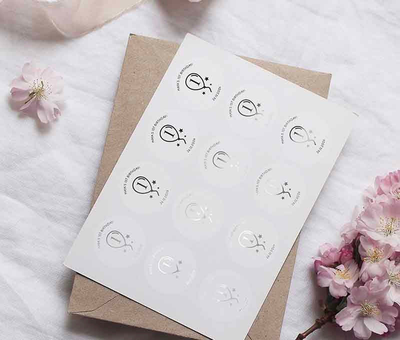 Birthday sticker sheet with a balloon graphic and personalized name and date printed in silver on a clear sticker