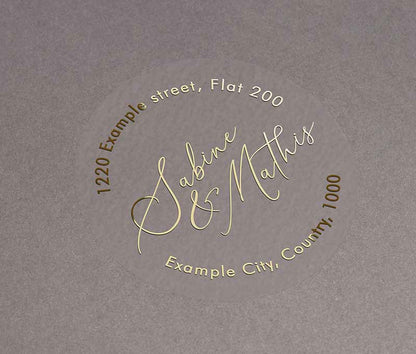 Return address labels printed in gold on clear round sticker with names in calligraphy font