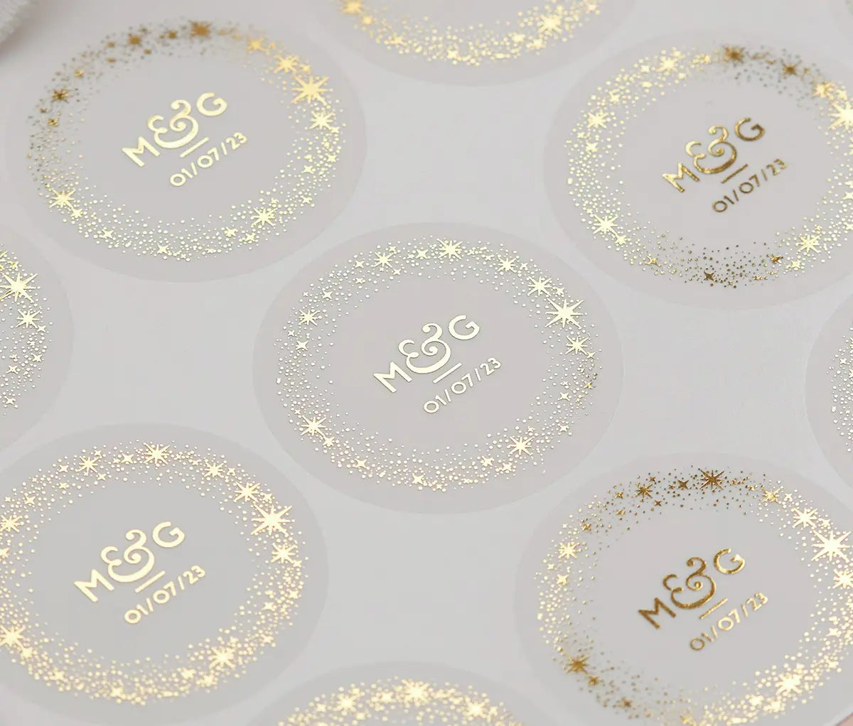 Sticker speet with personalized gold foil print initials, a date and a starry frame on round frosted stickers