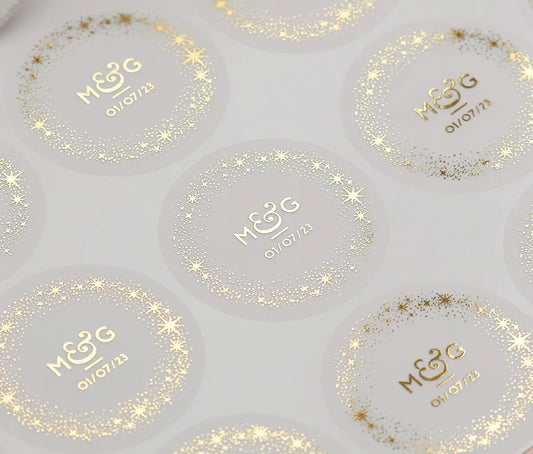 Sticker speet with personalized gold foil print initials, a date and a starry frame on round frosted stickers