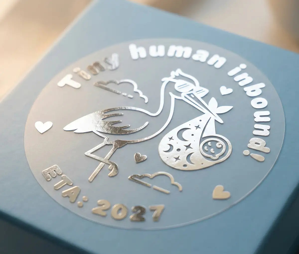 Silver foil Baby announcement sticker applied to baby blue gift box