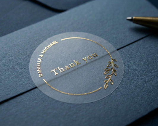 Wedding thank you sticker with personalized names and delicate floral theme frame printed in gold on clear sticker