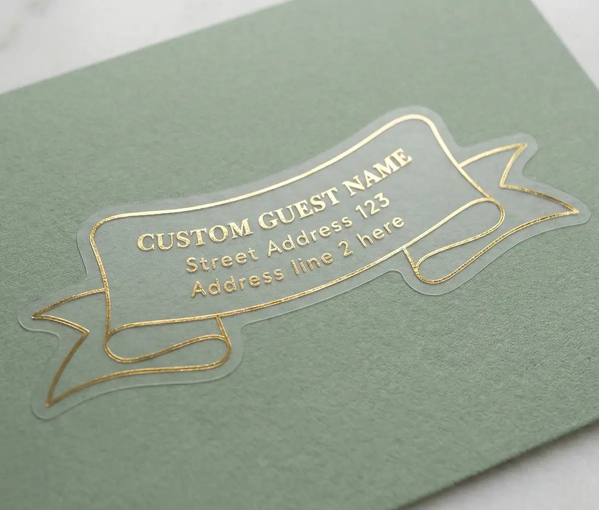Clear guest address label printed in gold foil and custom die cut in ribbon shape