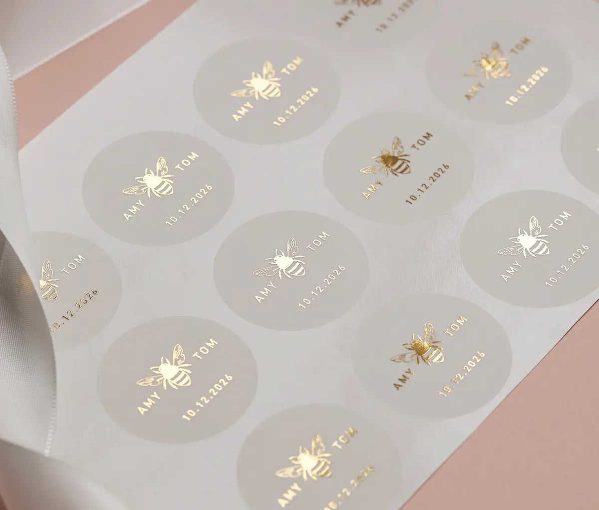 Sticker sheet of Honey bee graphic and personalized names printed and date printed in gold foil on round clear stickers.