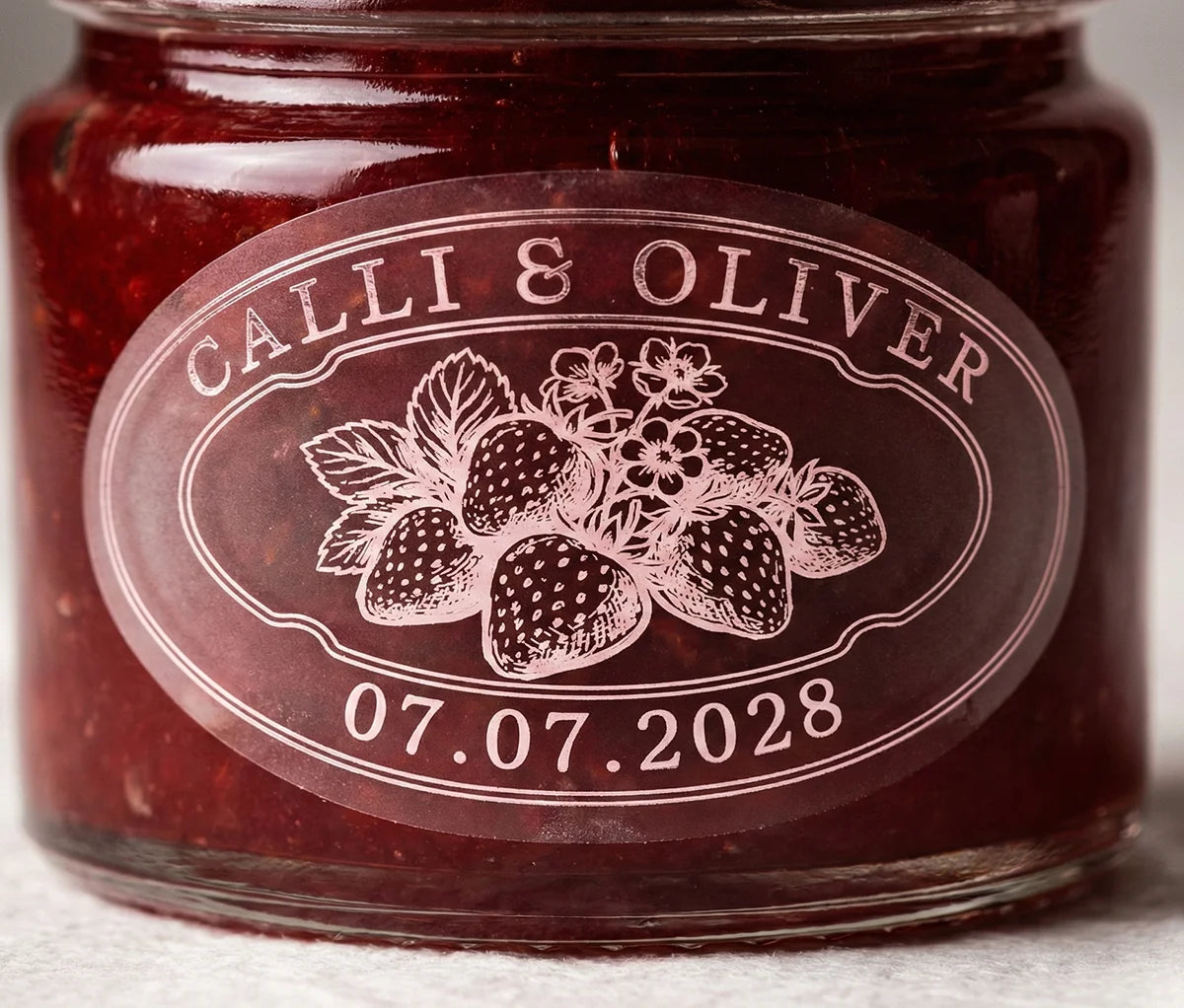 Jar of jam with personalized oval shape sticker printed in pale pink foil on transparent matte vinyl