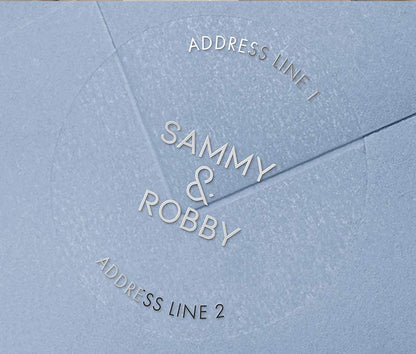 Return address labels with silver foil printing on clear round labels, applied to an envelope.