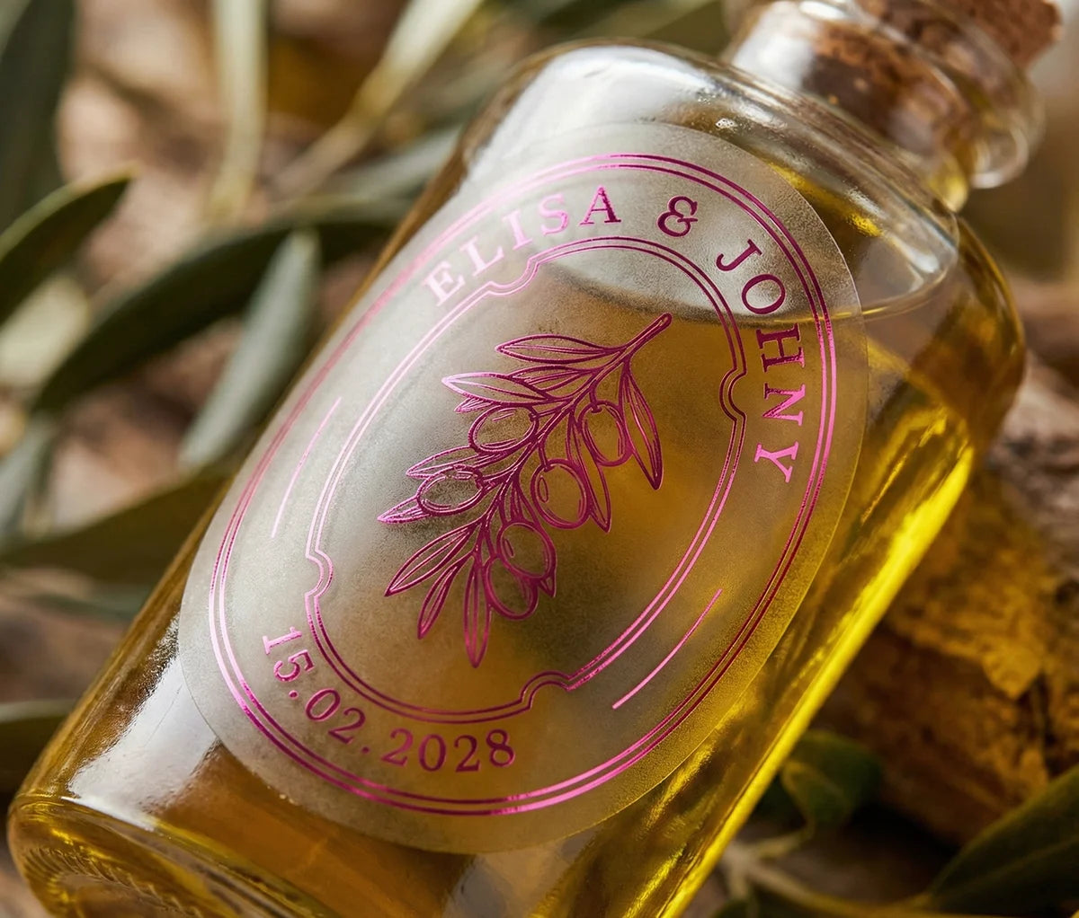 Oil proof oval, frosted olive oil favor label printed in hot pink foil applied to olive oil bottle.