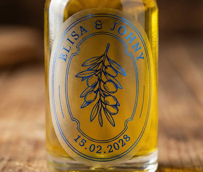 Oval, frosted olive oil favor label with custom names and date printed in royal blue oil applied to a glass bottle.