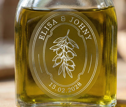 Glass bottle of olive oil with personalized oval frosted sticker printed in silver foil.