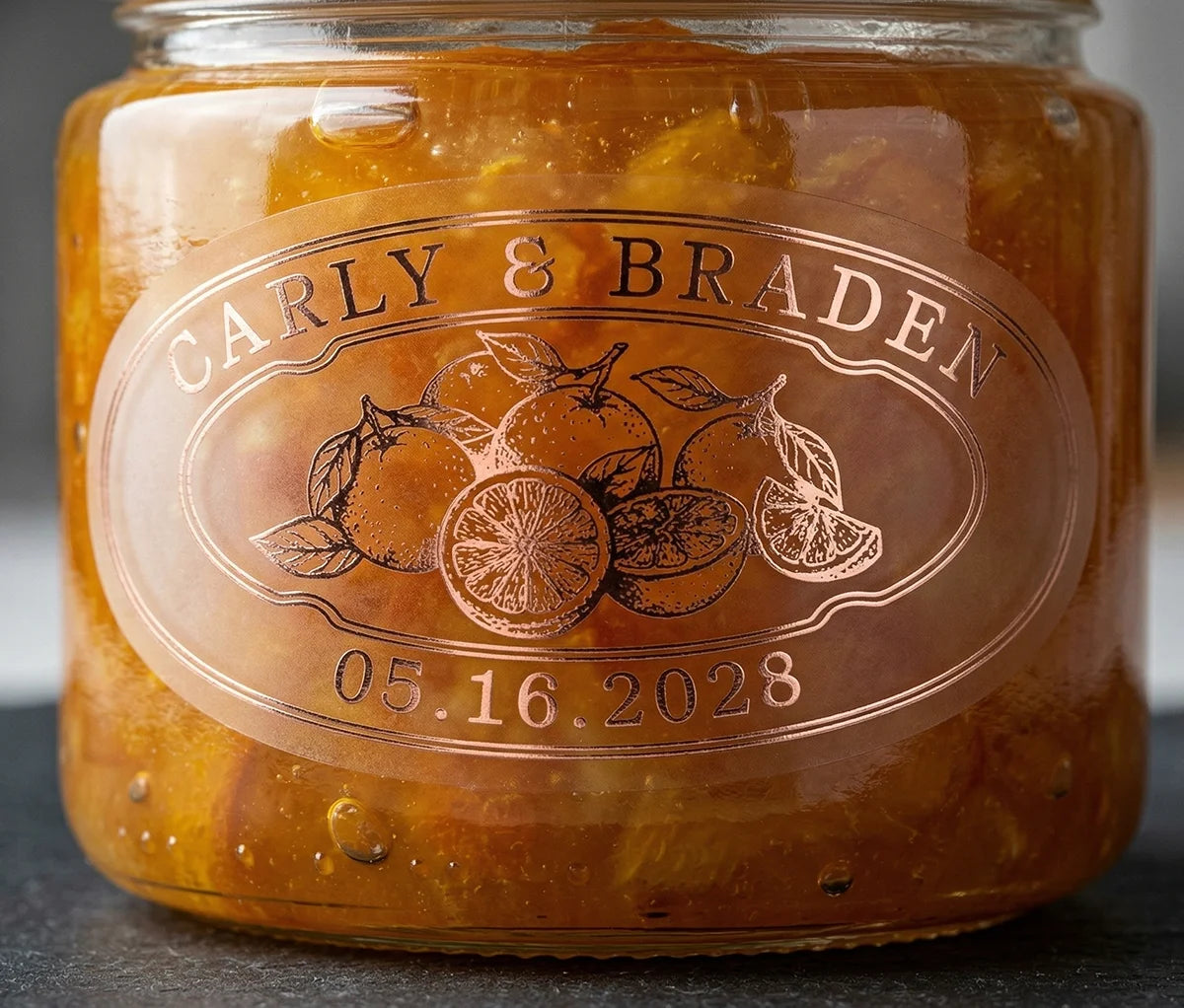 Oval personalized rose gold print transparent wedding favour label for orange marmalade on a jar.