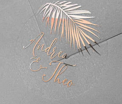 Tropical wedding envelope sticker with personalized names and palm leaf graphic printed in rose gold on round transparent frosted label