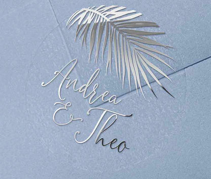 Tropical wedding envelope sticker with personalized names and palm leaf graphic printed in silver on round transparent frosted label