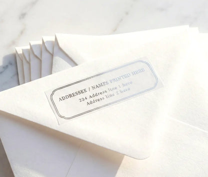 White envelope with luxurious return address label printed in silver foil on transparent vinyl.