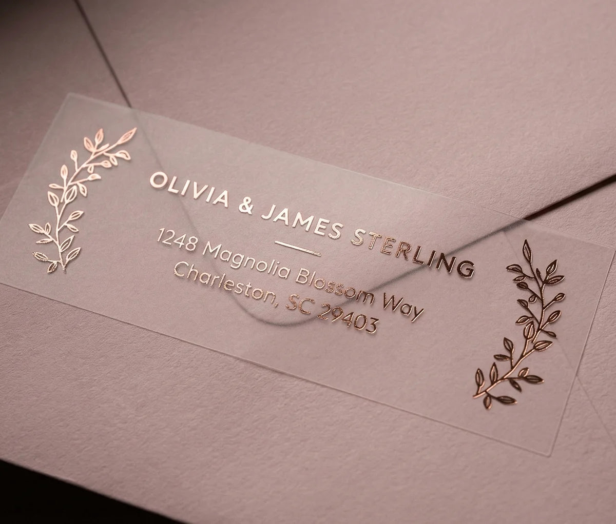 Return Address Label with Laurel Leaf Motif printed in rose Gold foil on transparent matte labels applied to a dusty pink envelope.