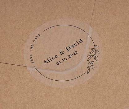 Save The Date sticker with personalised names and date and thin frame with leaves printed in black on clear round label