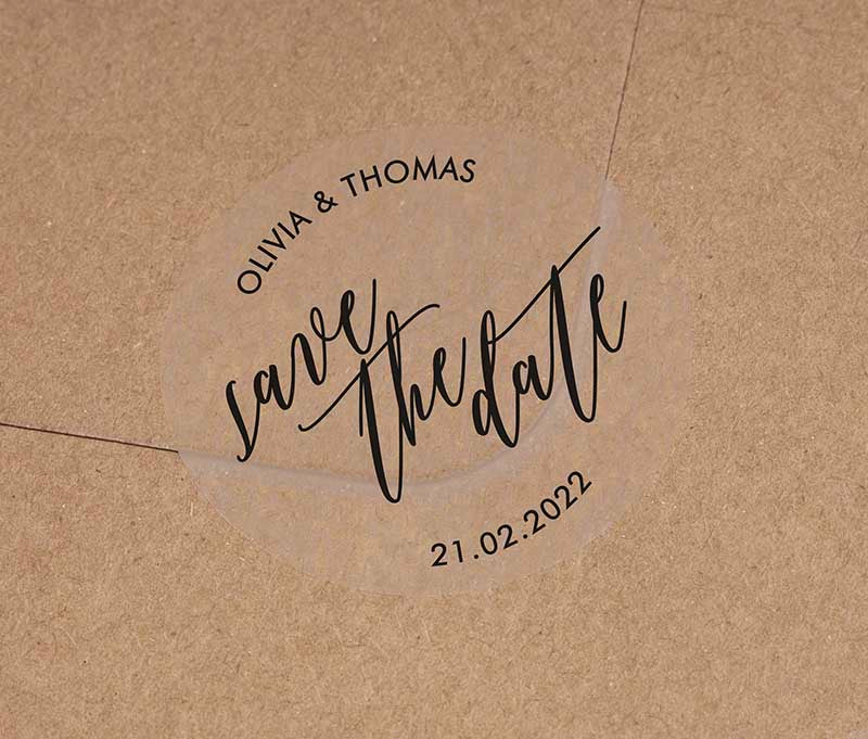 Save the date sticker with personalized names and date printed in black on round clear label