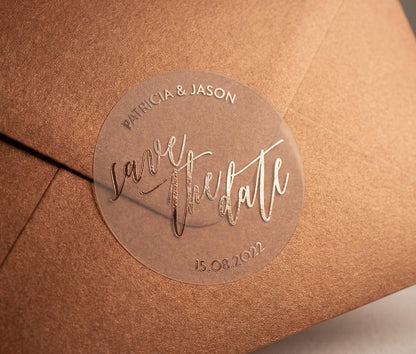 Bronze colour envelope with a clear 'save the date' sticker featuring custom names and date printed in rose gold foil.