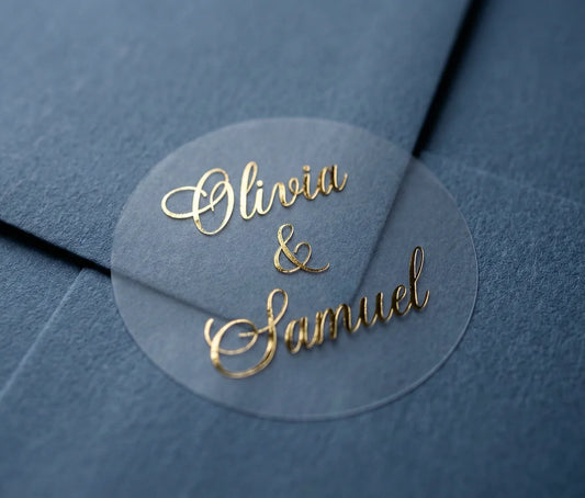 Gold foil personalized names printed on round sticker applied to a slate blue envelope.