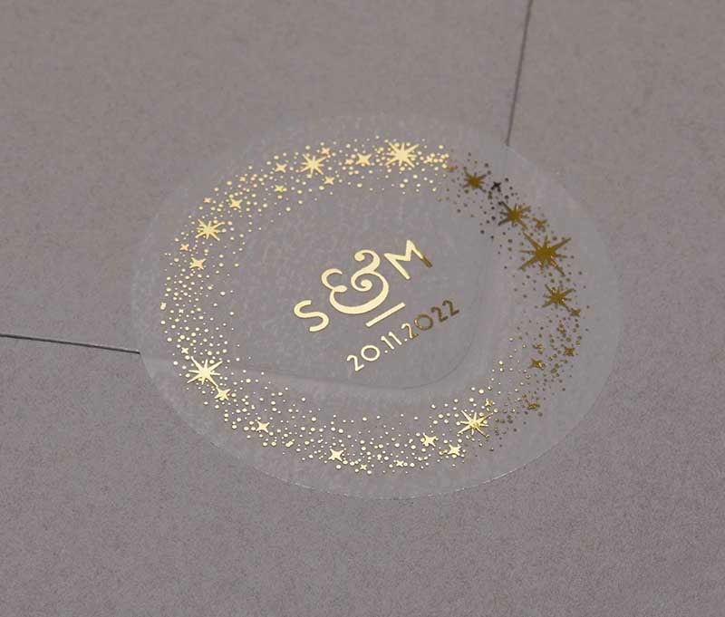 Celestial wedding favor stickers with stars around personalised initials and date printed in gold on clear sticker