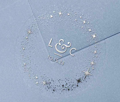 Celestial wedding favor stickers with stars around personalised initials and date printed in silver on clear sticker