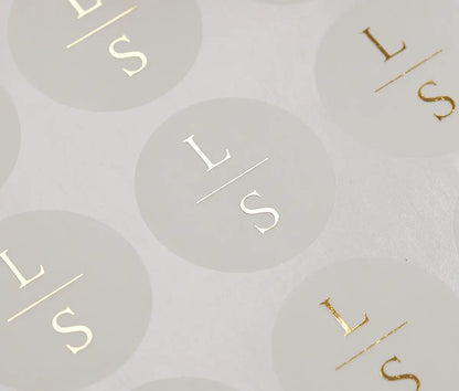 Personalized initials printed in gold foil on round clear sticker sheet