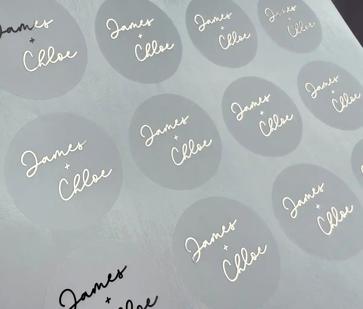 Personalized names in script font and plus sign printed in silver on clear wedding envelope sticker sheet