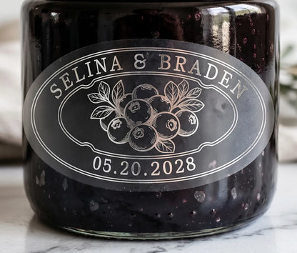 Oval personalized silver foil print frosted wedding favour label on a blueberry jam jar.