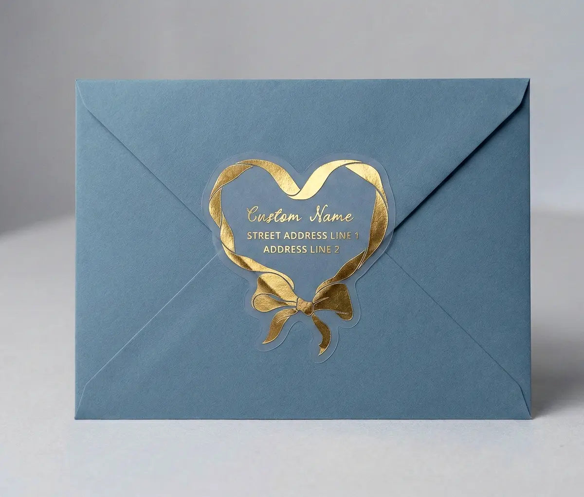 Return address label printed in gold foil applied to a blue colour envelope with custom die cut coquette heart shape.